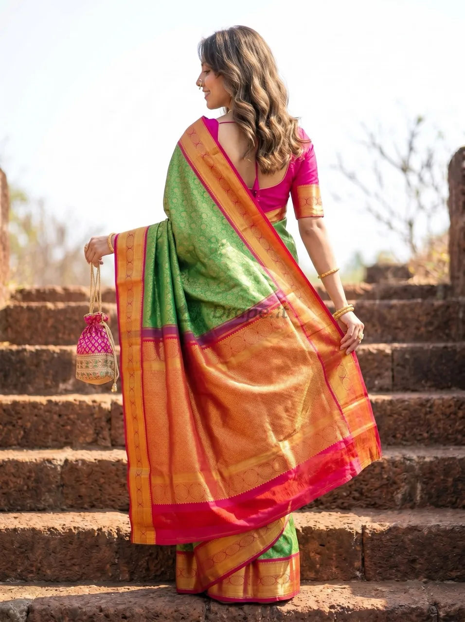 Model photoshoot of a green Kanjivaram-style silk saree with pink and gold zari pallu