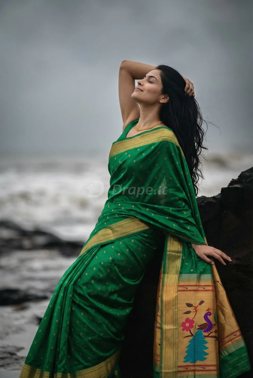 Saree campaign creative — green Paithani silk saree in a moody seaside setting